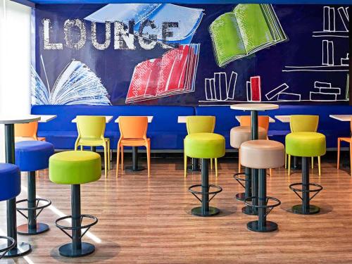 a room with colorful chairs and tables in a restaurant at ibis budget Curitiba Centro in Curitiba
