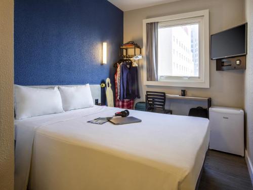 a bedroom with a large white bed and a window at ibis budget Sao Paulo Morumbi in Sao Paulo