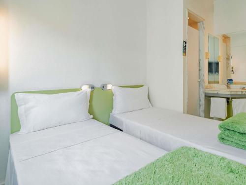two beds sitting next to each other in a room at ibis budget Sao Paulo Jardins in Sao Paulo