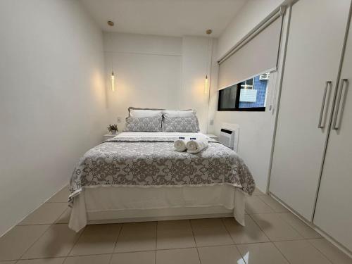a white bedroom with a bed and a window at Place Beira Mar in Recife