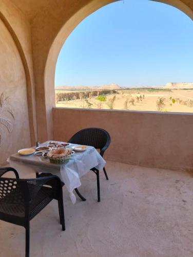a table and chairs with a view of the desert at sabrina camp in Siwa