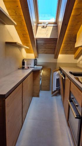a kitchen with wooden cabinets and a skylight at Apartment 5 Torri, parcheggio in garage in Cortina dʼAmpezzo