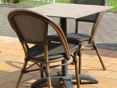 a table and two chairs sitting next to a table at Ibis Budget Agen in Le Passage