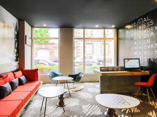 a living room with a red couch and tables at Ibis Budget Albi Centre in Albi