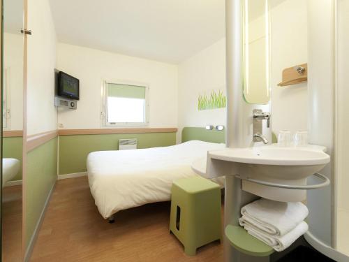 a small bathroom with a bed and a sink at Ibis budget Orléans Sud Comet in Orléans