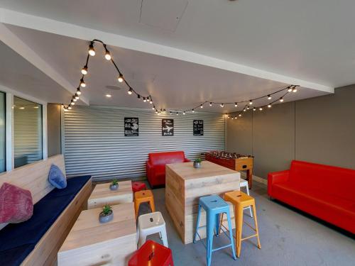 a living room with a red couch and chairs at ibis budget Sydney Airport in Sydney