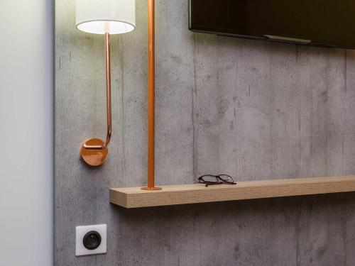 a lamp on a shelf next to a wall at ibis budget Metz Technopole in Metz