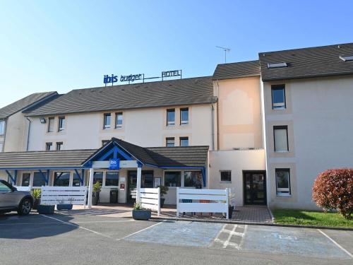 a building with a car parked in a parking lot at Hotel ibis Budget Laval in Bonchamp-lès-Laval