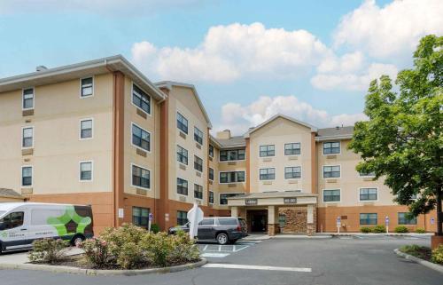 a large building with cars parked in a parking lot at Extended Stay America Suites - New York City - LaGuardia Airport in Queens
