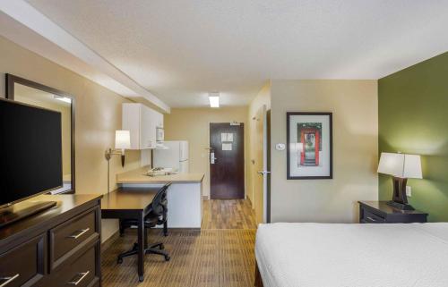 a hotel room with a bed and a desk with a computer at Extended Stay America Suites - New York City - LaGuardia Airport in Queens