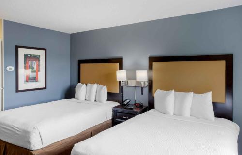 two beds in a hotel room with blue walls at Extended Stay America Suites - New York City - LaGuardia Airport in Queens