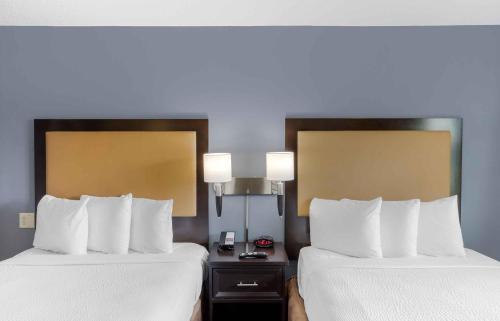 two beds in a hotel room with white sheets at Extended Stay America Suites - New York City - LaGuardia Airport in Queens
