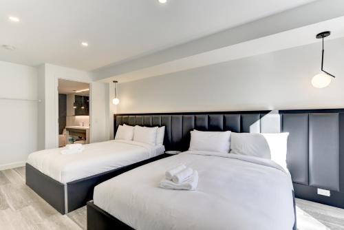two beds with white sheets in a bedroom at CLUBHAUS Hotel in Montréal