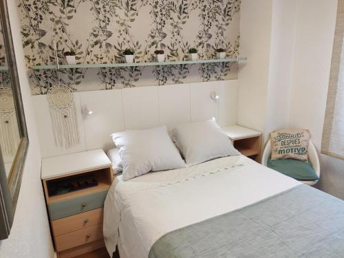 Un pequeño dormitorio con una cama y una silla. en Happy Travel, en Madrid
