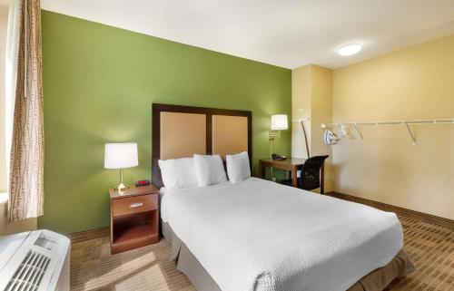 a bedroom with a large bed and a green wall at Extended Stay America Suites - Baltimore - Glen Burnie in Glen Burnie