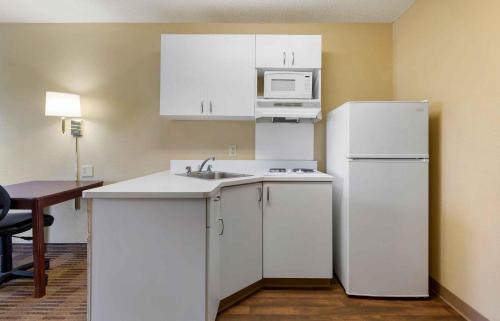a kitchen with white cabinets and a white refrigerator at Extended Stay America Suites - Baltimore - Glen Burnie in Glen Burnie