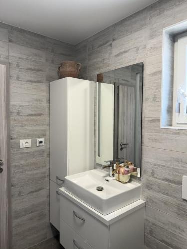 a bathroom with a white sink and a mirror at Apartment Mani in Koper