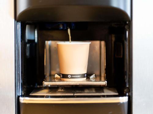 a cup of coffee is inside of a microwave at ibis budget Aix en Provence in Aix-en-Provence