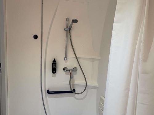 a shower in a bathroom with a shower head at Ibis Budget Ancenis in Mésanger