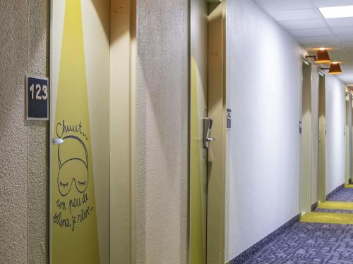 a hallway with a door with a sign on it at ibis budget Amboise in Amboise
