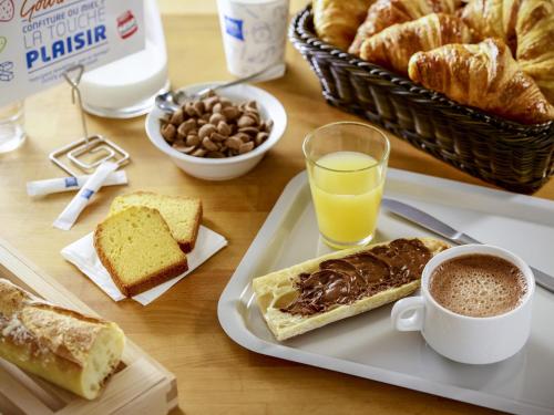 a table with a plate of pastries and a cup of coffee at ibis budget Amboise in Amboise