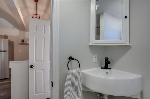 a white bathroom with a sink and a mirror at 2-bed rm house on the lake in Merrimac