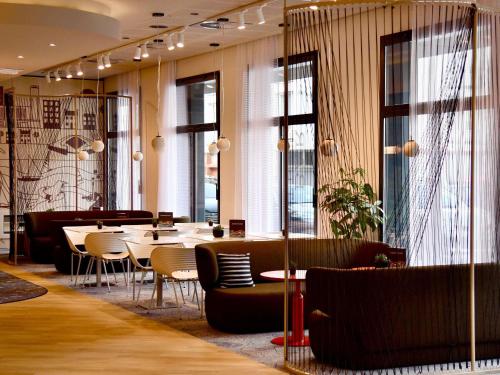 a dining room with tables and chairs and windows at ibis budget Brest Centre Port in Brest