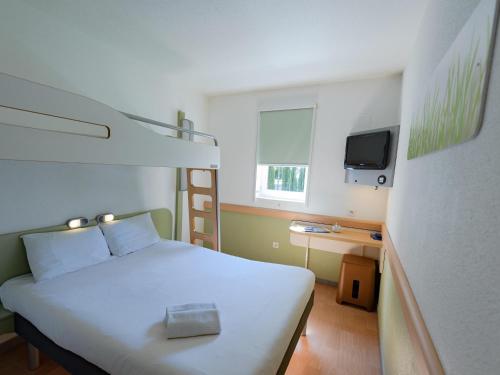 a bedroom with a white bed and a television at ibis budget Orange Centre in Orange