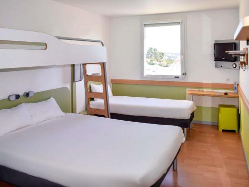 a room with two bunk beds and a television at Ibis Budget Marseille Valentine in Marseille
