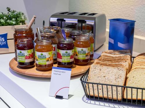 a counter with bread and jars of jam and peanut butter at ibis budget Besançon Ecole Valentin in Besançon