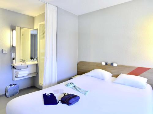 Cette chambre comprend 2 lits et un lavabo. dans l'établissement Ibis Budget Nantes Rezé Aéroport, à Rezé