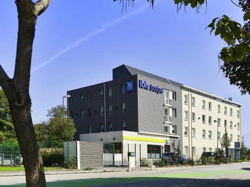 a large building with a hotel in front of it at Ibis Budget Grenoble Sud Seyssins in Seyssins