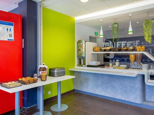 a fast food restaurant with green and yellow walls at Ibis Budget Grenoble Sud Seyssins in Seyssins