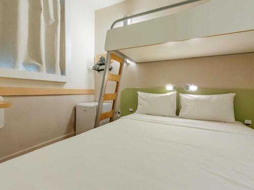 a bed in a room with a bunk bed at ibis budget Vitoria in Vitória