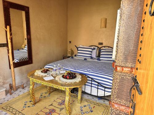 a bedroom with a bed with a table and a mirror at Nana Diafa - Luxury Stay in Zagora in Zagora