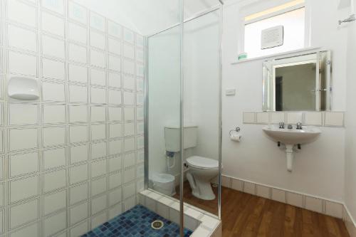 a bathroom with a toilet and a sink at Scarborough Apartments in Perth