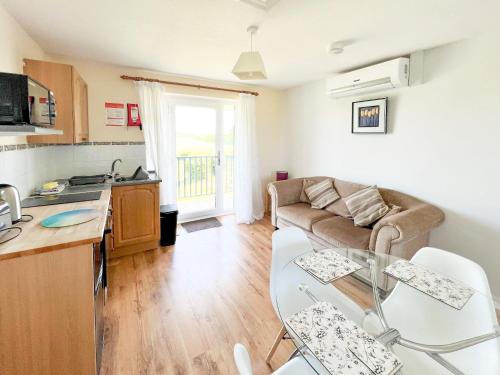 eine Küche und ein Wohnzimmer mit einer Couch und einem Tisch in der Unterkunft Willow Apartment - Uk49303 in Woolfardisworthy