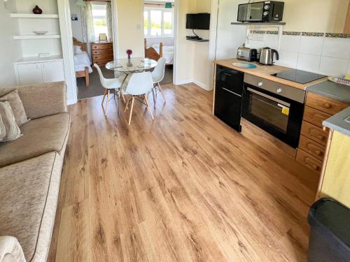 eine Küche und ein Wohnzimmer mit einem Tisch und einer Couch in der Unterkunft Willow Apartment - Uk49303 in Woolfardisworthy