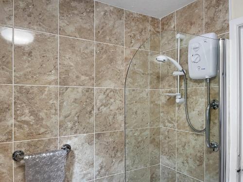 a bathroom with a shower with a shower head at Eastry Cottage in Castleton