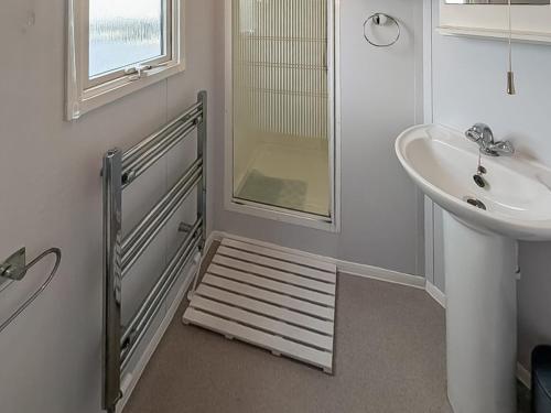 a bathroom with a sink and a shower and a staircase at Amanda in Kinmel Bay