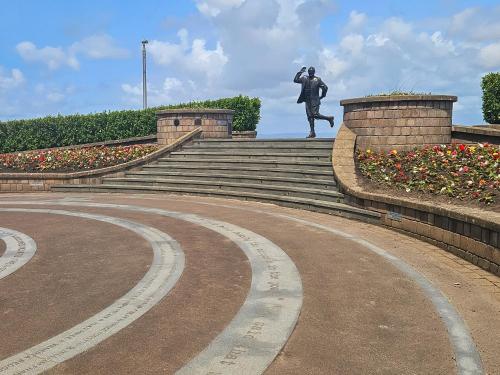 a statue of a man running up some stairs at Ocean Breeze in Heysham