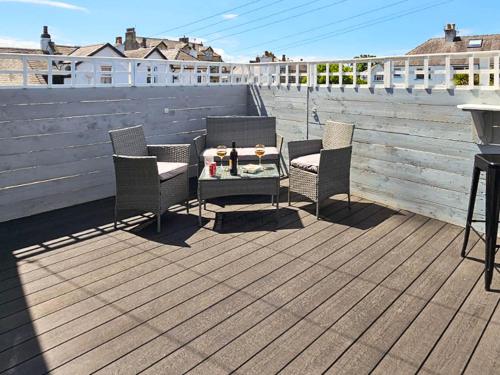 a patio with a table and chairs on a deck at Ocean Breeze in Heysham