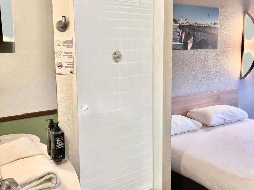 a door leading to a bedroom with a bed at Hotel Ibis Budget Cosne Sur Loire in Cosne Cours sur Loire