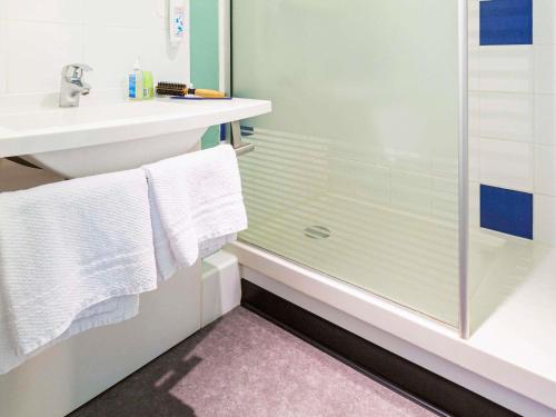 a bathroom with a shower and a sink at ibis budget Angoulême Nord in Champniers