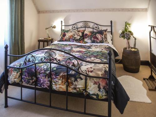 a bedroom with a bed with a floral bedspread at Millside Holidays in Stalham