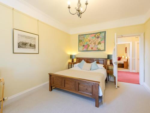 a bedroom with a bed and a chandelier at Wintonhill Farmhouse - Uk50381 in Pencaitland