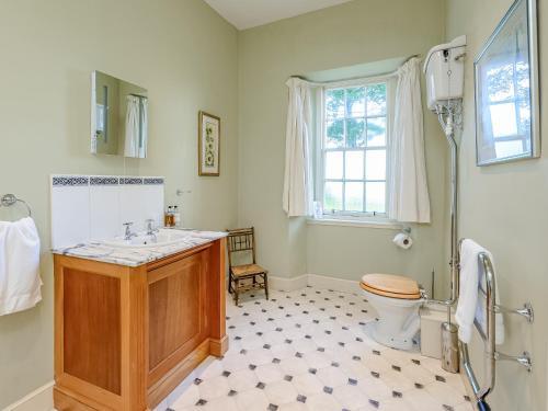a bathroom with a sink and a toilet and a window at Wintonhill Farmhouse - Uk50381 in Pencaitland