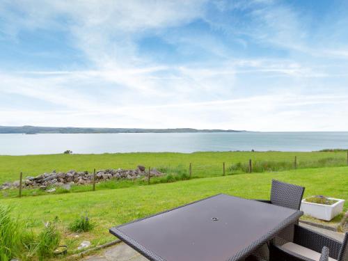a picnic table with a view of the water at Ach-Na-Clachan in Gairloch
