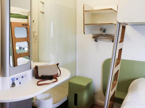a small room with a bunk bed and a mirror at ibis budget Castelnaudary - A61 in Castelnaudary