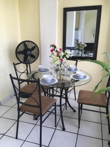 a dining room table with chairs and a mirror at Posada Colonial Beach Villas in San Juan